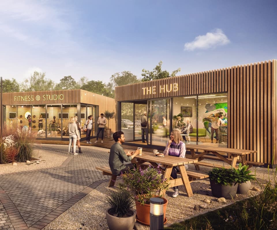 The Hub — a timber-clad amenity building with a fitness studio, café and picnic benches on a logistics park